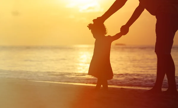 Siluety otce a malá dcerka procházky při západu slunce — Stock fotografie