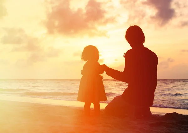 Père et petite fille se tenant la main au coucher du soleil — Photo