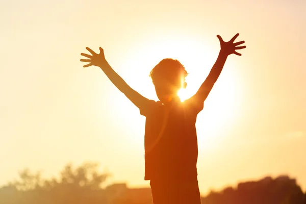 Pequeno menino feliz no céu por do sol — Fotografia de Stock