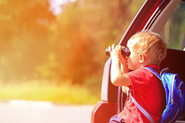 Bambino guardando attraverso binocoli viaggiare in auto — Foto Stock