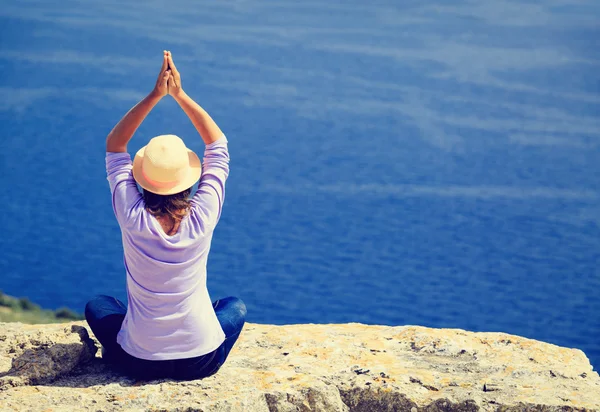 Ung kvinne som praktiserer yoga i fjell – stockfoto