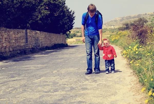 Padre e hija pequeña caminando en el camino — Foto de Stock