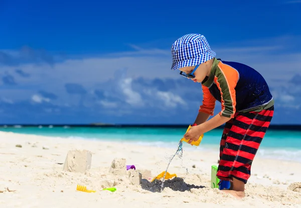 Mały chłopiec bawiący się piaskiem na plaży — Zdjęcie stockowe