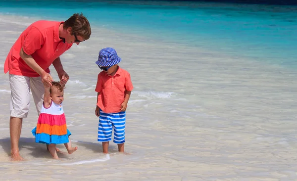 Pai e crianças brincando de férias no mar — Fotografia de Stock