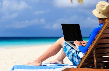 adam ile tatil tropikal üstünde laptop