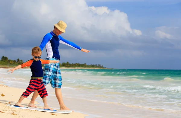 Vader en zoontje leren surfen op zomer strand — Stockfoto