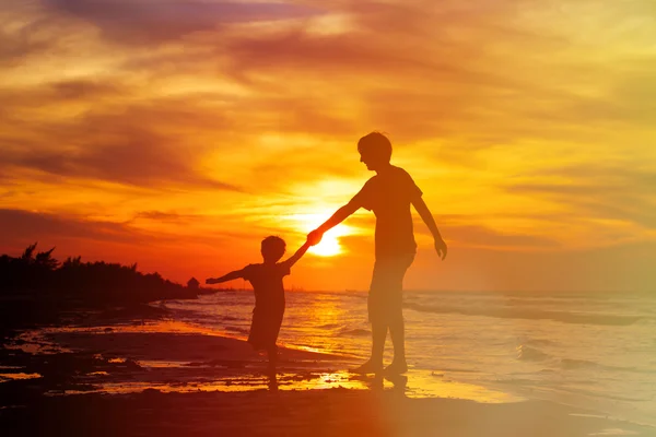 Père et fils s'amuser sur la plage du coucher du soleil — Photo