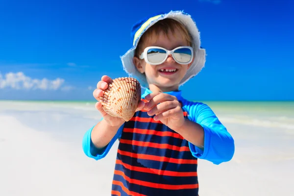 Маленький хлопчик знайшов мушлі на літньому пляжі — стокове фото