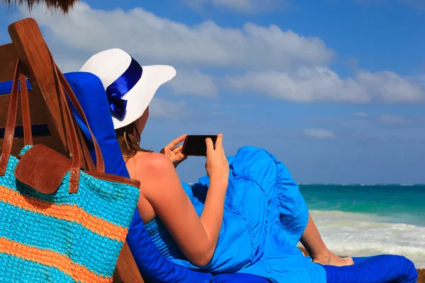 Женщина с мобильным телефоном на тропическом пляже — стоковое фото