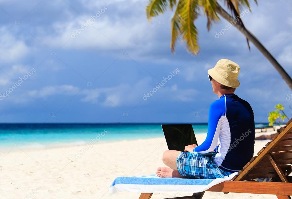 man with laptop on tropical vacation