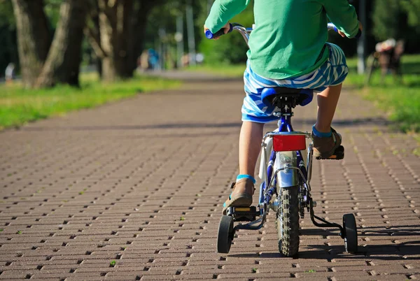 Bambino in sella alla bici nel parco — Foto Stock