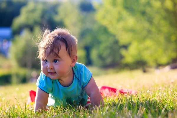 Pequeno bebê aprendendo a rastejar no parque de verão — Fotografia de Stock