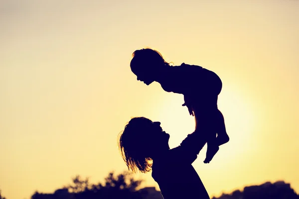 Sagome di padre e figlioletta che giocano al tramonto — Foto Stock