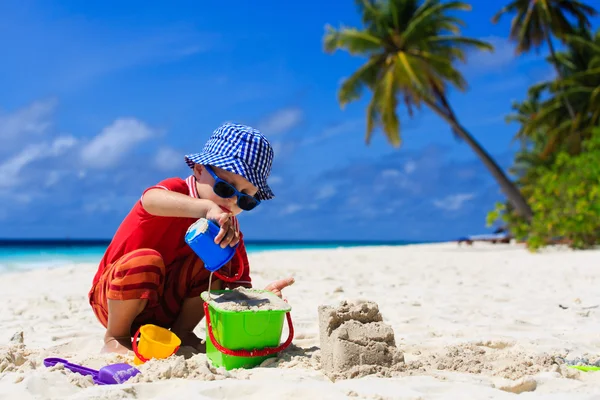 Kind gebouw zand kasteel op tropisch strand — Stockfoto