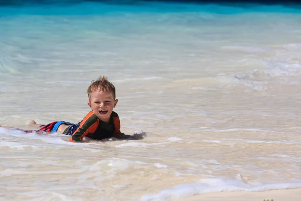 Mały chłopiec pływanie na plaży — Zdjęcie stockowe