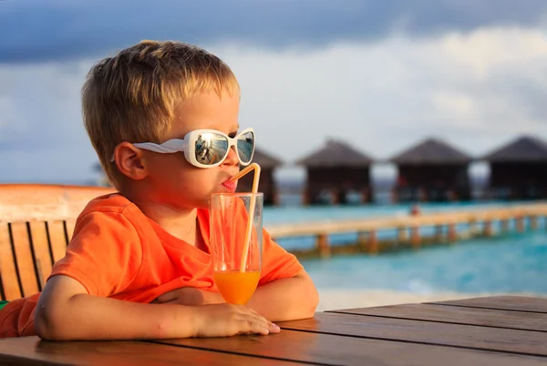 Küçük çocuk tropik sahilde kokteyl içme — Stok fotoğraf