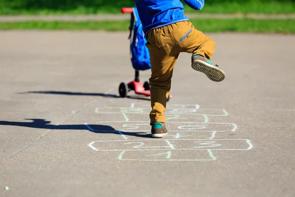 Liten pojke spela hoppa hage på lekplats — Stockfoto