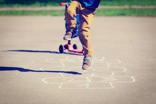 Kleiner Junge spielt Hopscotch auf Spielplatz — Stockfoto