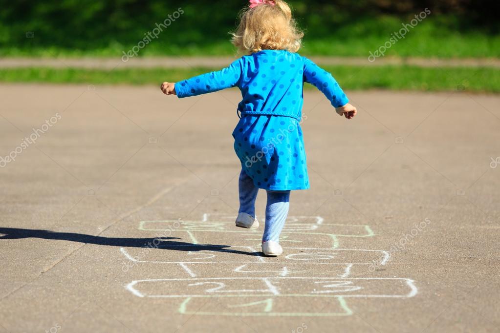 Menina brincando de amarelinha no playground