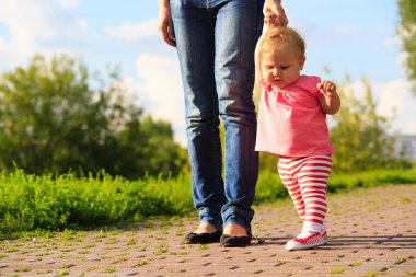 küçük kız parkta ilk adımları yapmak