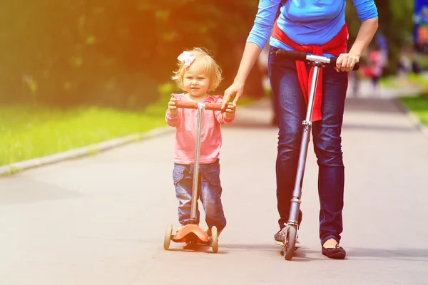 母亲和滑板车在城市中的小女儿 — 图库照片