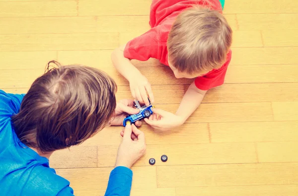 Vater bringt Sohn bei, wie man Spielzeugauto repariert — Stockfoto