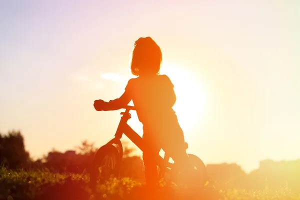 Menina andando de bicicleta ao pôr do sol, crianças ativas — Fotografia de Stock
