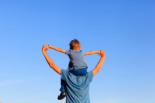 Happy father and son on shoulders play at sky — Stock Photo, Image