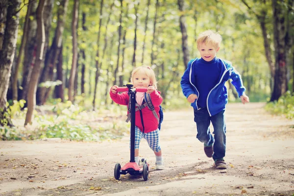 Küçük kız scooter ve çalışan, çocuk sürme çocuklar spor — Stok fotoğraf