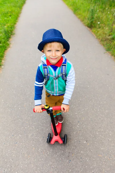 Kleiner Junge fährt mit dem Roller zur Schule, Blick aus dem Hochwinkel — Stockfoto