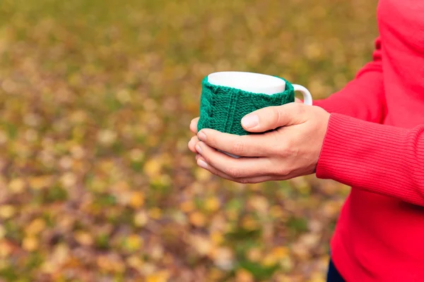 Mujer sosteniendo la taza de té o café en otoño otoño — Foto de Stock