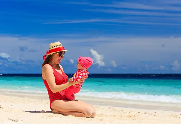 Mother playing with little daughter on the beach — Stock Photo, Image