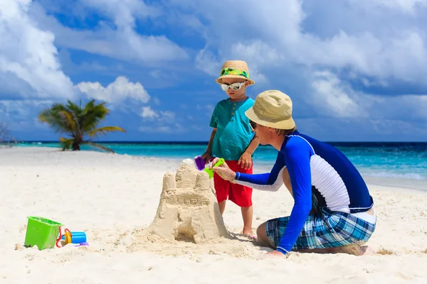 Père et fils construisant château sur la plage — Photo