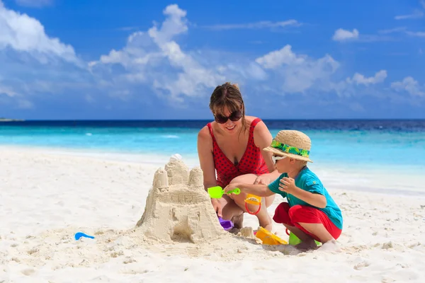 母亲和儿子建筑在沙滩上的城堡 — 图库照片
