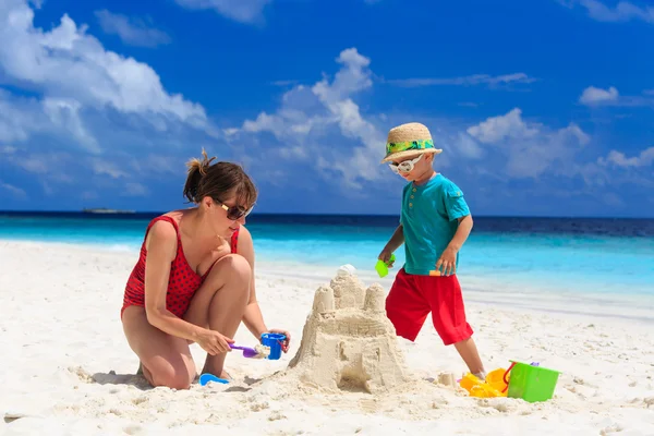 Moeder en zoon gebouw kasteel op het strand — Stockfoto