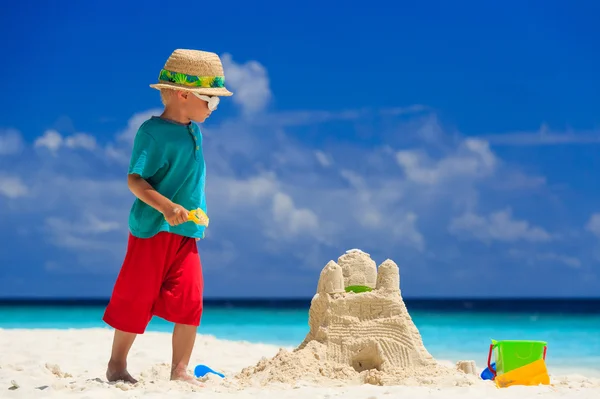 Bambino costruzione castello di sabbia sulla spiaggia tropicale — Foto Stock