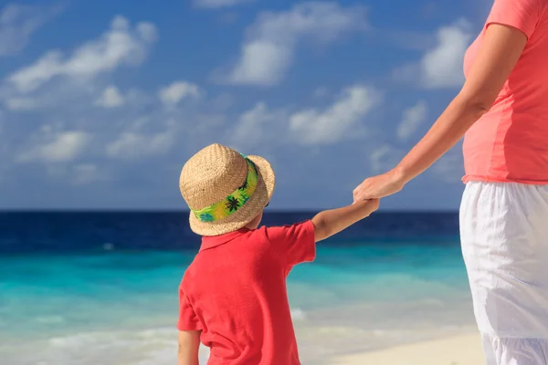 Madre e hijo tomados de la mano en la playa — Foto de Stock