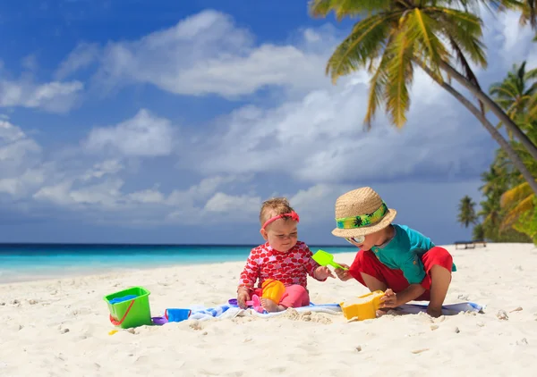 哥哥和妹妹在热带海滩上玩 — 图库照片