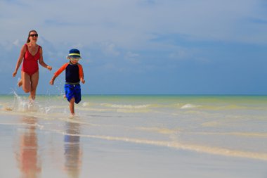 Anne ve oğlu sahilde suda çalışan