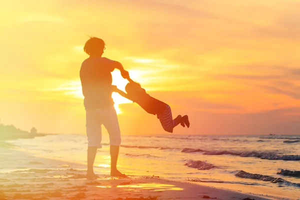 Батько і маленький син грають на заході сонця — стокове фото