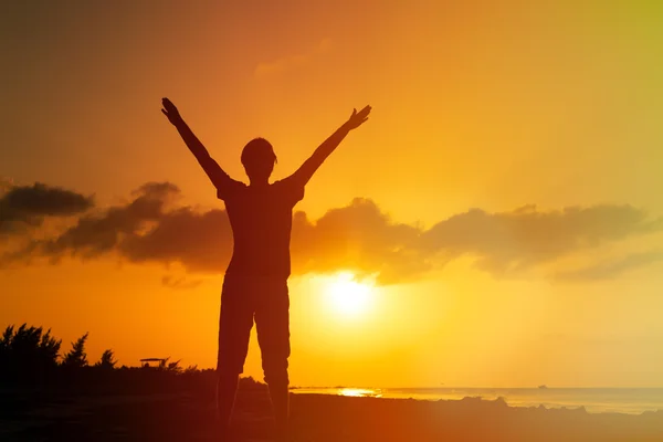 Man with his hands up on sunset beach — Stock Photo, Image