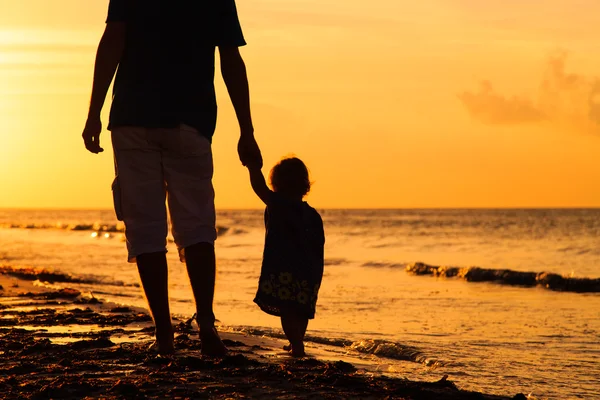Silhouettes de père et petite fille marchant au coucher du soleil — Photo