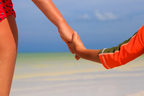 Madre e bambino che si tengono per mano sulla spiaggia del mare — Foto Stock