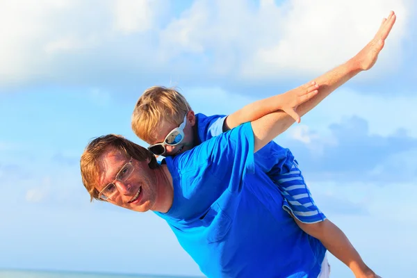 Padre e hijo pequeño jugando en el cielo azul — Foto de Stock