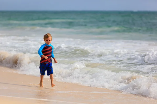 Mały chłopiec biegną na piasek plaża tropikalny — Zdjęcie stockowe