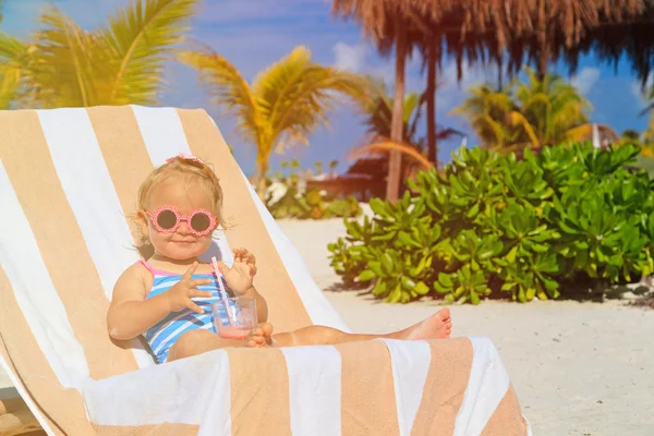 Roztomilá holčička pití šťávy na tropické pláži — Stock fotografie