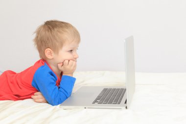 Küçük çocuk dizüstü bilgisayara bakıyor