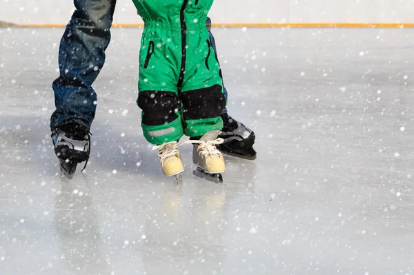 Pai e criança aprendendo a patinar no inverno — Fotografia de Stock