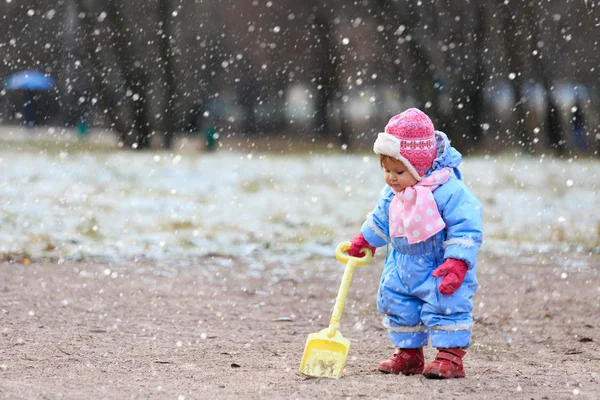 Маленькая девочка играет в снежном зимнем парке — стоковое фото