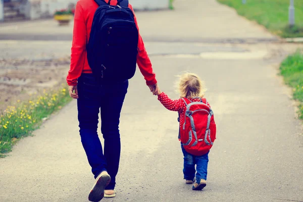 Mother holding hand of little daughter with backpack — Stock Photo, Image